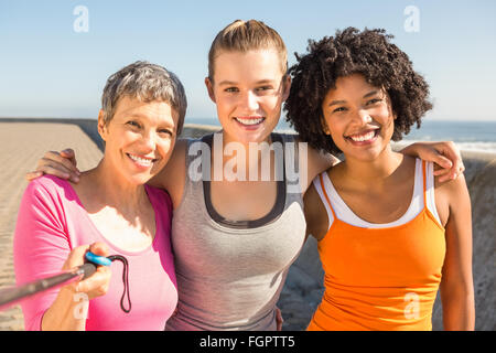 Smiling sporty women taking autoportraits avec selfiestick Banque D'Images