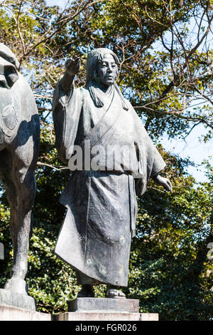 Le Japon, Kochi castle. Taka-jo. Statue de Yamauchi Chiyo. Femme vêtue de happi traditionnelle japonaise, avec couche de fond d'arbres. Banque D'Images