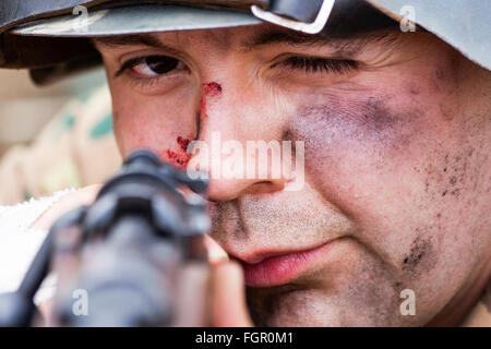 Seconde guerre mondiale re-enactment. Close up de visage de soldat allemand, AIM, à la visée de son fusil. Eye-contact. Banque D'Images