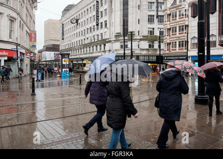 Manchester, UK - 17 Février 2016 : un groupe de femmes avec des parasols traversant les jardins de Piccadilly, Manchester sur un jour d'hiver humide Banque D'Images