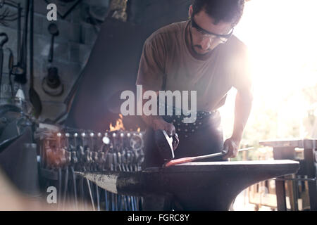 Blacksmith forge fer chaud à enclume dans forge Banque D'Images