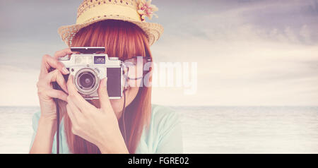 Image composite de portrait of a smiling woman holding hipster caméra rétro Banque D'Images