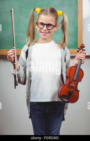 Cute élève holding violin in a classroom Banque D'Images