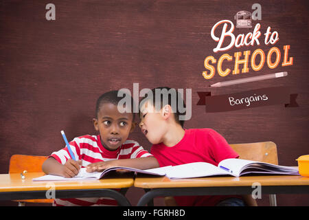 Image composite de cute pupils écrit at desk in classroom Banque D'Images