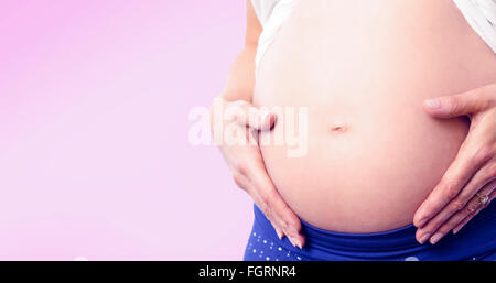 Image composite de pregnant woman holding her bump Banque D'Images