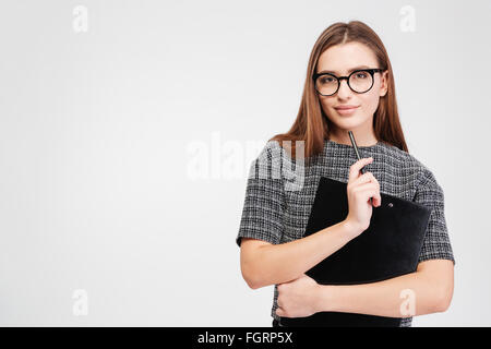 Portrait of attractive confident businesswoman dans les verres avec le presse-papier et stylo sur fond blanc Banque D'Images