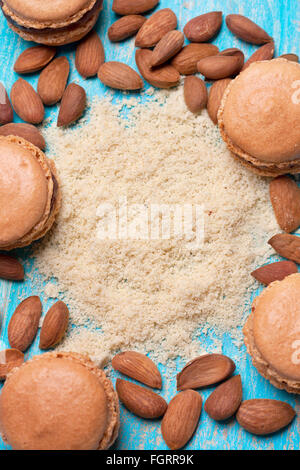 La farine d'amande, amande, macaron bleu sur fond de bois (vue de dessus) Banque D'Images