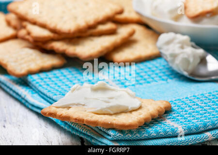 Collation de craquelins et fromage à la crème sur serviette bleu Banque D'Images