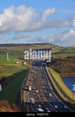 Trafic lourd voyageant sur la m62 en passant les moulins à vent près de moss moor huddersfield yorkshire uk Banque D'Images