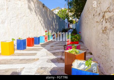 Une île grecque typique ruelle pavée à Chora, Mykonos, Grèce décoré avec des pots de fleur de géranium et entouré b Banque D'Images