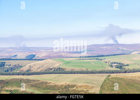 La fumée s'élevant dans le ciel de la lointaine moorland incendies dans le Peak District, Derbyshire frontière du Yorkshire, England, UK Banque D'Images