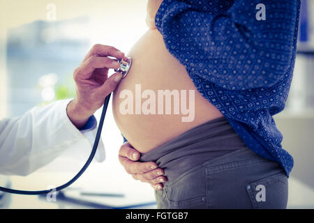 Portrait of doctor examining pregnant woman in clinic Banque D'Images