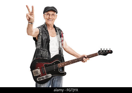 Bassiste punk Senior tenant une guitare et faire un geste de la main de la paix isolé sur fond blanc Banque D'Images