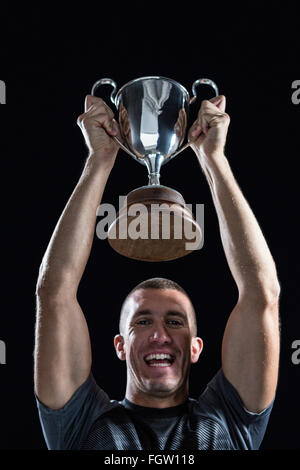 Portrait de joueur de rugby avec succès holding trophy Banque D'Images