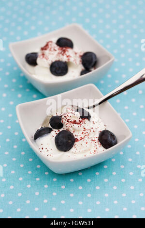 Skyr surmontée de bleuets et de canneberge en poudre. Banque D'Images