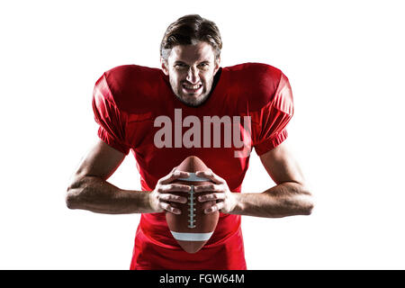 Joueur de football américain agressif en maillot rouge holding ball Banque D'Images