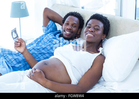 Smiling relaxed couple lying on bed Banque D'Images