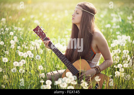 Femme Hippie avec guitare en été meadow . L'harmonie de la Nature Banque D'Images