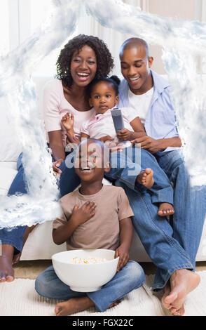 Image composite de l'heureuse famille regardent la télévision ensemble Banque D'Images