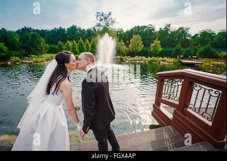 Le marié et la mariée à pied près du lac le jour de leur mariage Banque D'Images