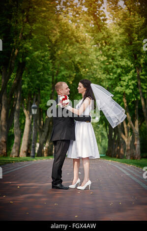 Jeune couple en train de marcher ensemble main dans la main au parc d'été Banque D'Images