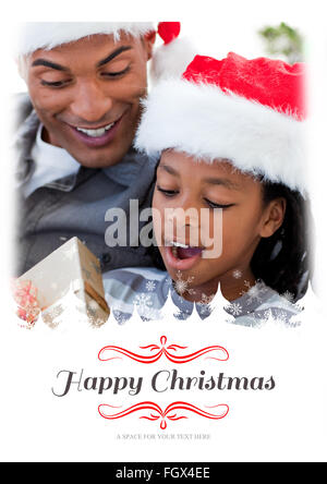 Image composite de portrait d'un père et son fils l'ouverture d'un cadeau de Noël Banque D'Images