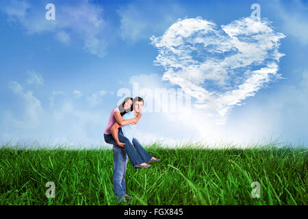 Image composite de young man giving girlfriend a piggyback ride Banque D'Images