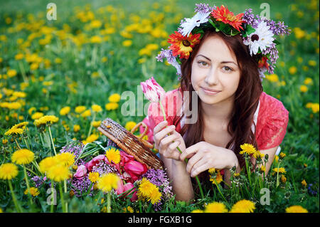 Belle femme d'une gerbe couchée sur l'herbe dans un pré Banque D'Images