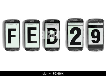 Fév 29 écrit sur les écrans de smartphones photographié sur un fond blanc. Banque D'Images
