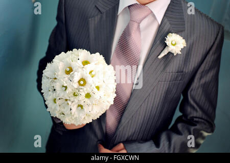 Groom organiser mariage bouquet dans sa main pour la mariée Banque D'Images