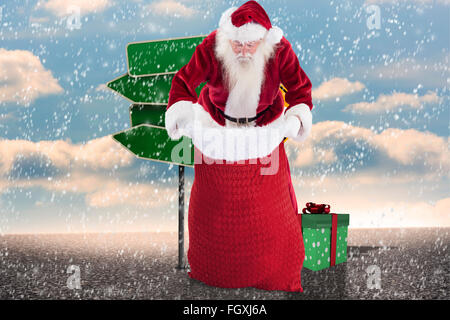 Image composite de santa cherche dans son sac Banque D'Images