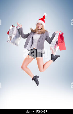 Blonde fête jumping with shopping bags Banque D'Images