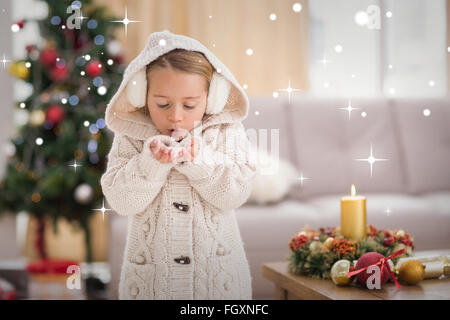 Image composite de petite fille de fête souffle sur les mains Banque D'Images