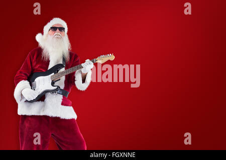 Image composite de santa claus joue de la guitare avec des lunettes Banque D'Images