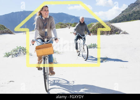 Image composite de carefree couple partir en promenade en vélo sur la plage Banque D'Images