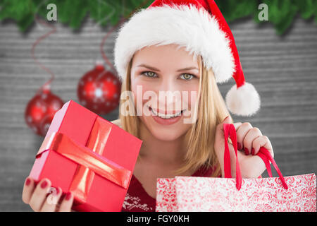 Image composite de woman smiling with christmas shopping Banque D'Images