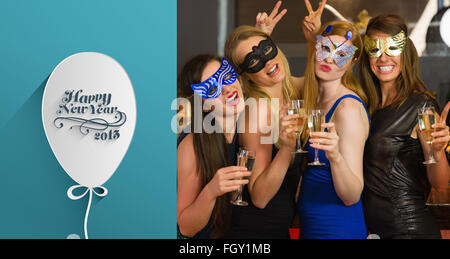 Image composite de l'attractive women wearing masks holding champagne Banque D'Images