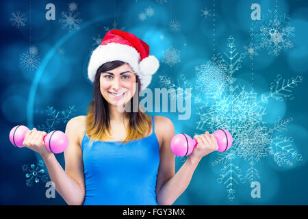 Image composite de mettre en place des fêtes brunette holding dumbbells Banque D'Images