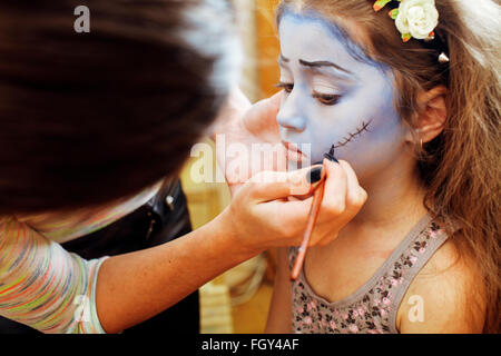 Mignon petit enfant faisant facepaint sur anniversaire, Apocalypse zombie, préparer Halloween facepainting Banque D'Images