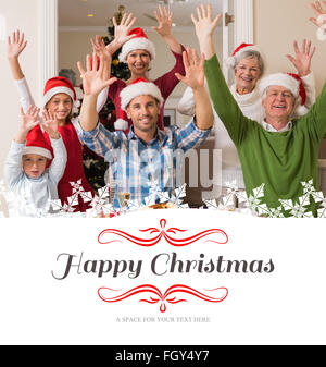 Image composite de extended family in santa hat cheering at camera Banque D'Images