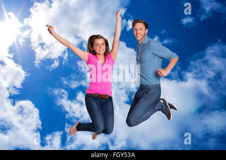 Image composite de cheerful young couple jumping Banque D'Images