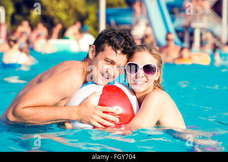 Couple avec des lunettes de soleil dans la piscine. L'été et l'eau. Banque D'Images