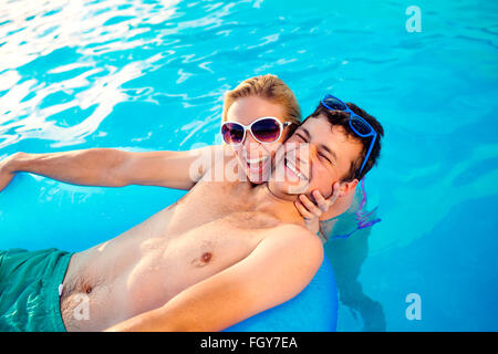 Couple avec des lunettes de soleil dans la piscine. L'été et l'eau. Banque D'Images