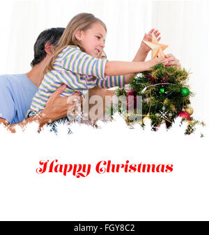 Image composite de petite fille en plaçant une étoile dans un arbre de Noël Banque D'Images