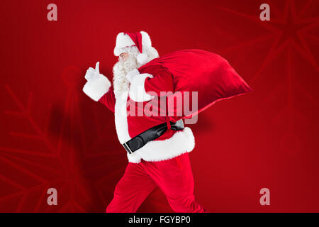 Image composite de santa positive avec un sac et Thumbs up Banque D'Images