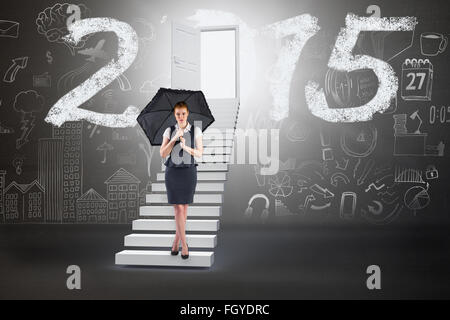 Image composite de pretty redhead businesswoman holding umbrella Banque D'Images