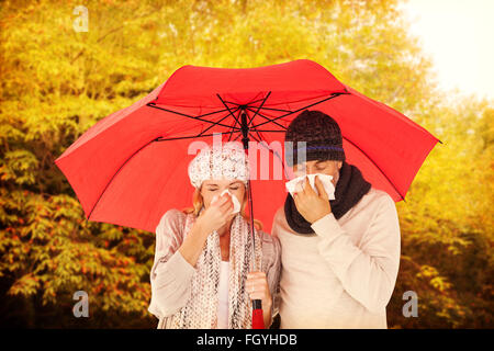 Image composite de mauvais couple éternuement dans les tissus tout en se tenant sous égide Banque D'Images