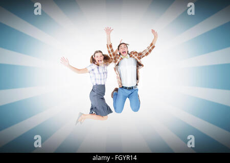 Image composite de geeky hipsters jumping and smiling Banque D'Images