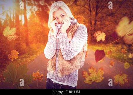 Image composite de blonde en vêtements d'hiver smiling at camera Banque D'Images