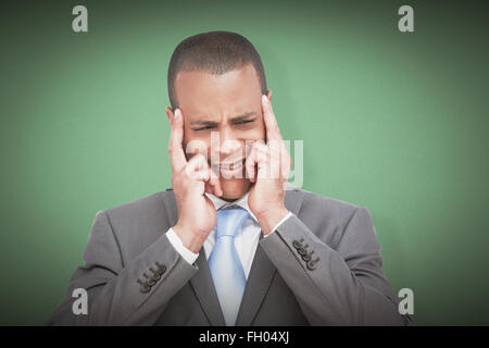 Composite image of businessman mettant ses doigts sur ses tempes Banque D'Images